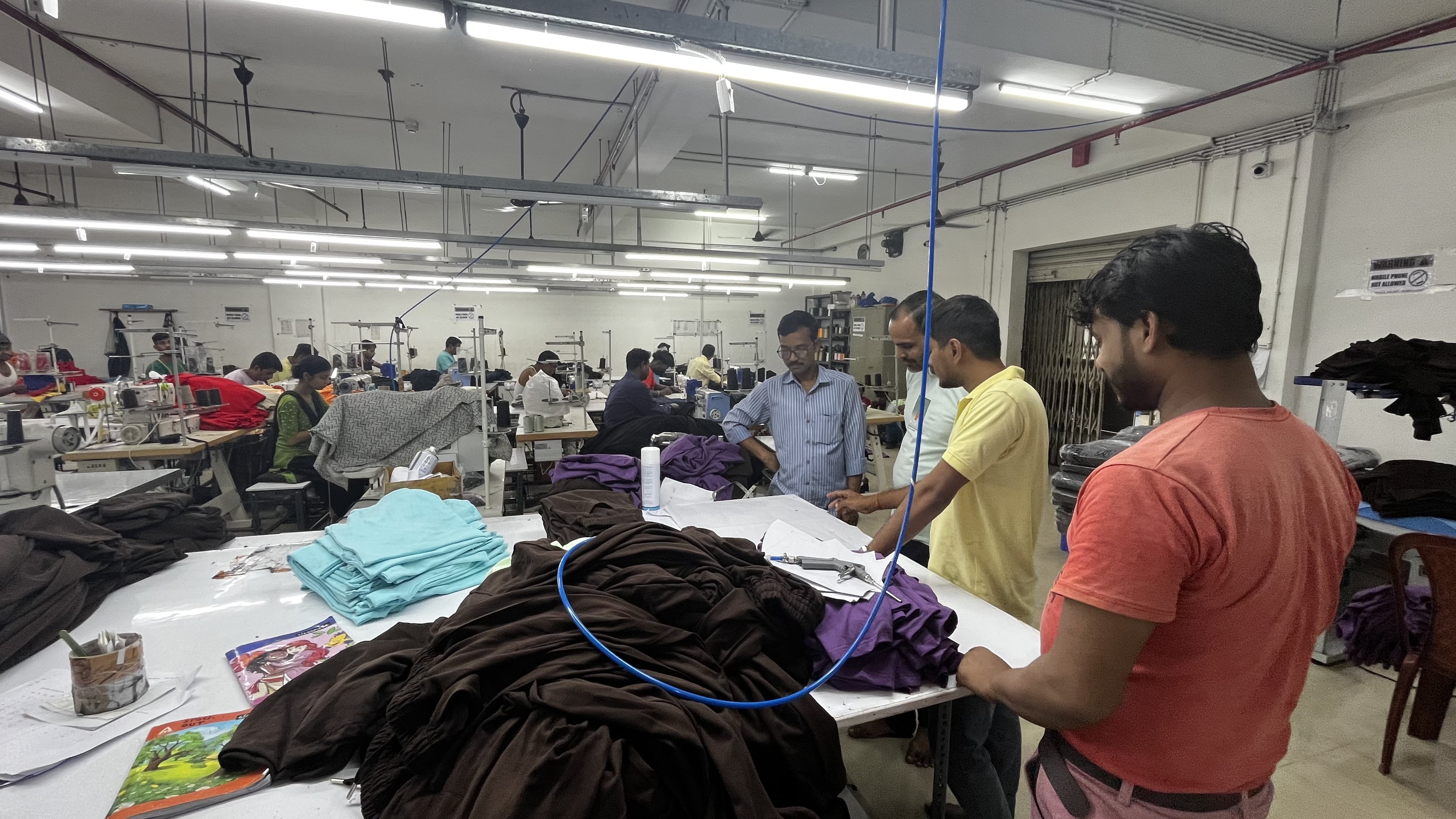Rigorous quality control station where every garment undergoes thorough inspection with testing equipment to ensure we meet international standards. Plakads Quality Control Checkpoint with Testing Equipment